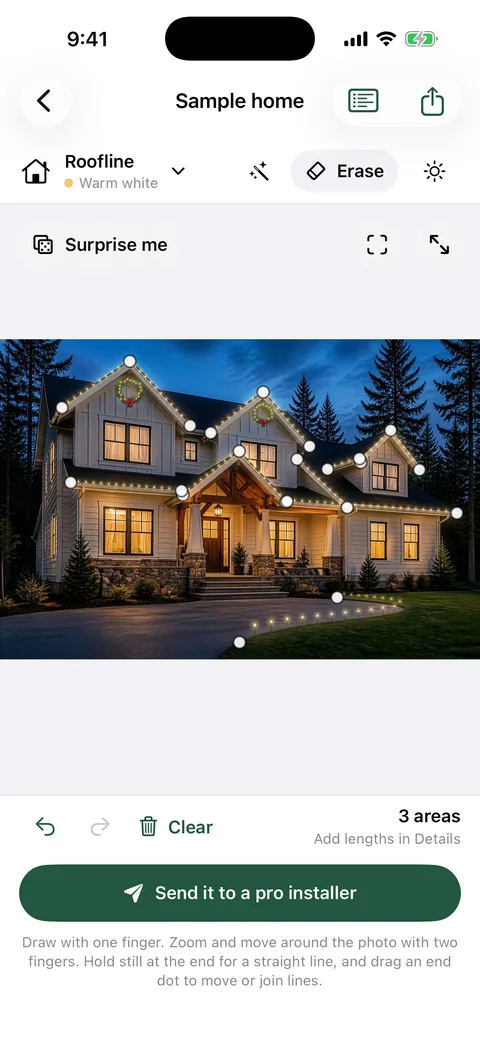 The sample home in GlowField after Design it for me, with warm white lights on the roofline and gables, two wreaths and path lights along the drive.